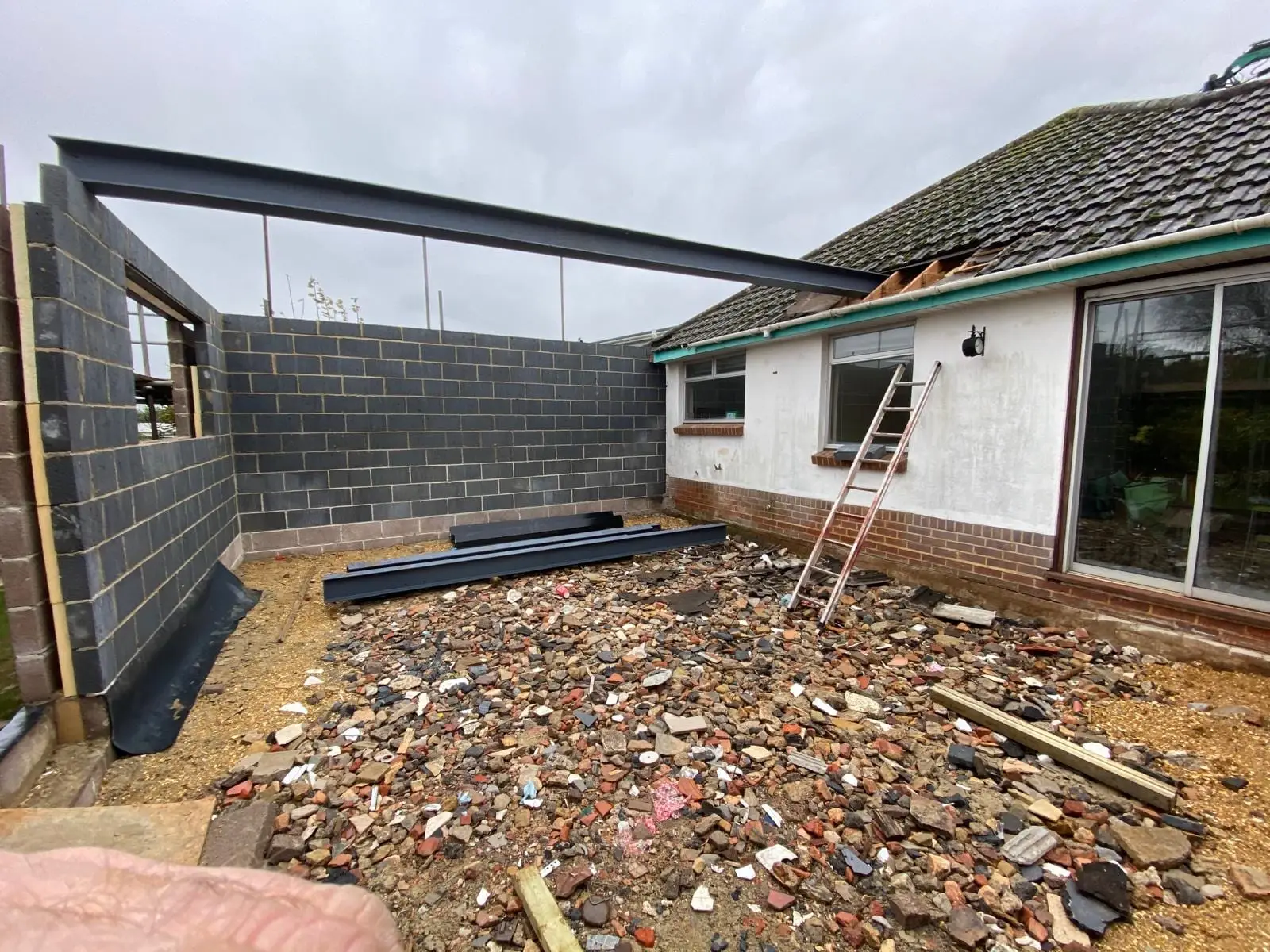 New blockwork walls and a steel goalpost frame around the rear of the bungalow