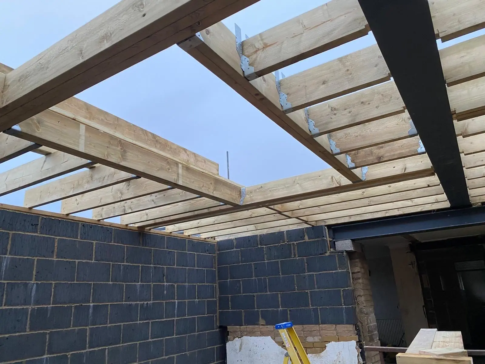 The new cut roof going on over the blockwork, with a steel beam carrying the far end