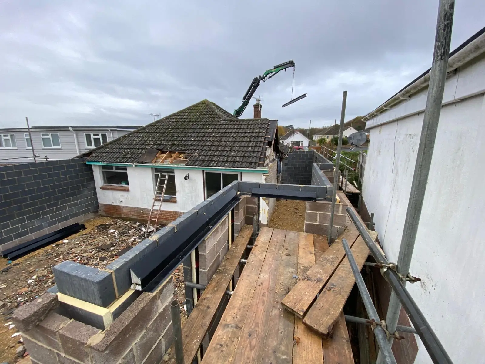 The steelwork and new blockwork seen from the scaffold, with the crane still on site