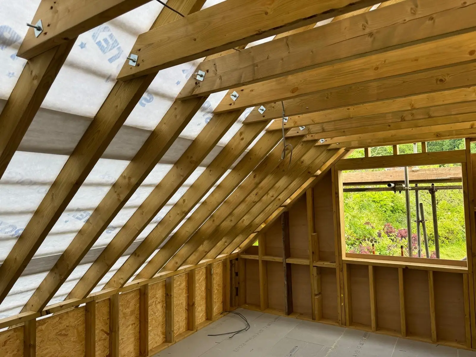 One of the new first floor rooms framed out, with the window opening formed and the garden beyond