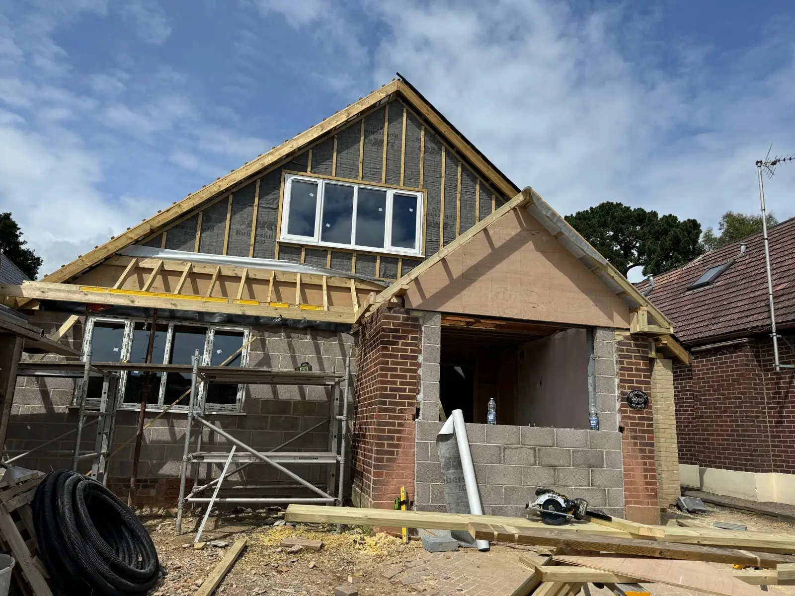 The new front gable built in blockwork with brick piers, and the porch opening formed