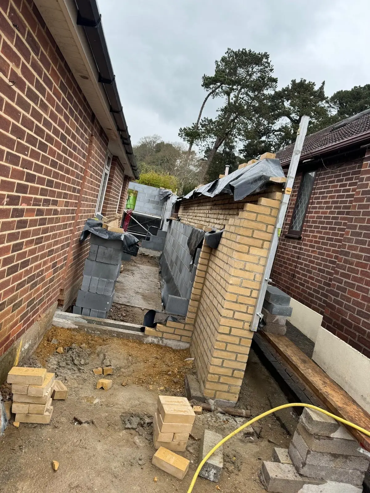 New blockwork and a buff brick pier being built up the narrow side passage