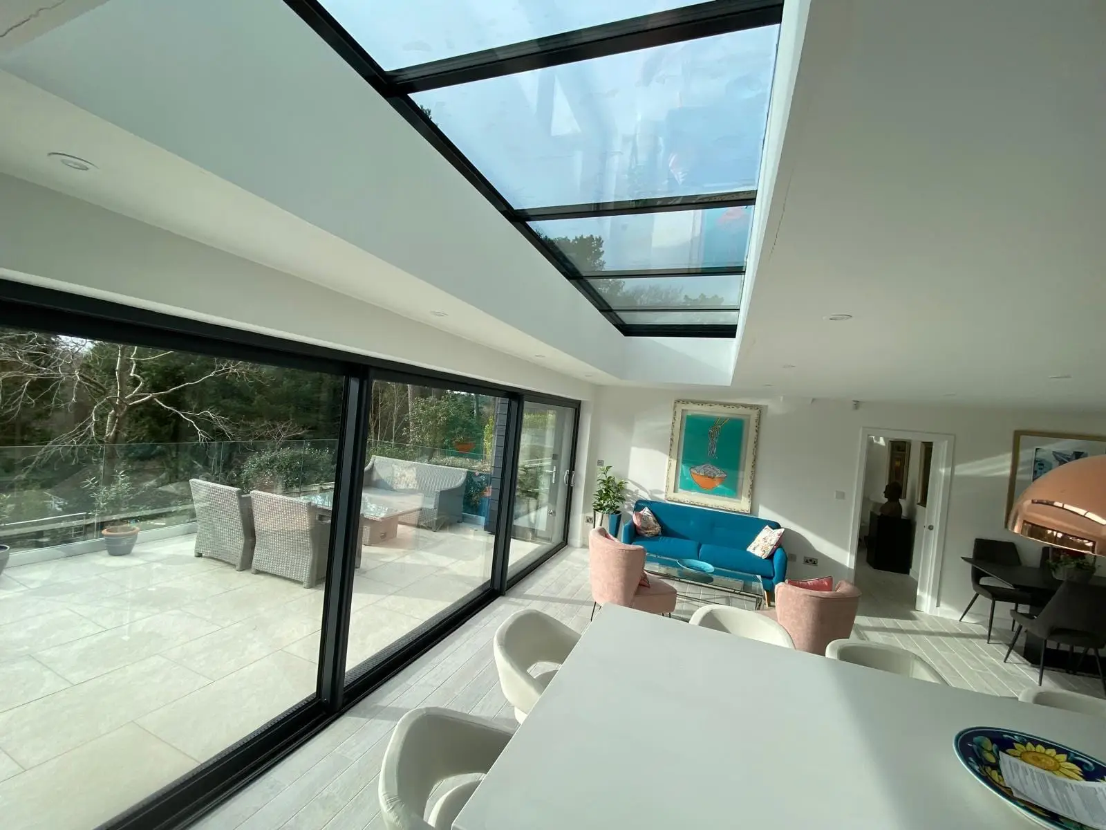 Inside the finished extension, looking out through the sliding doors under the glass roof lantern