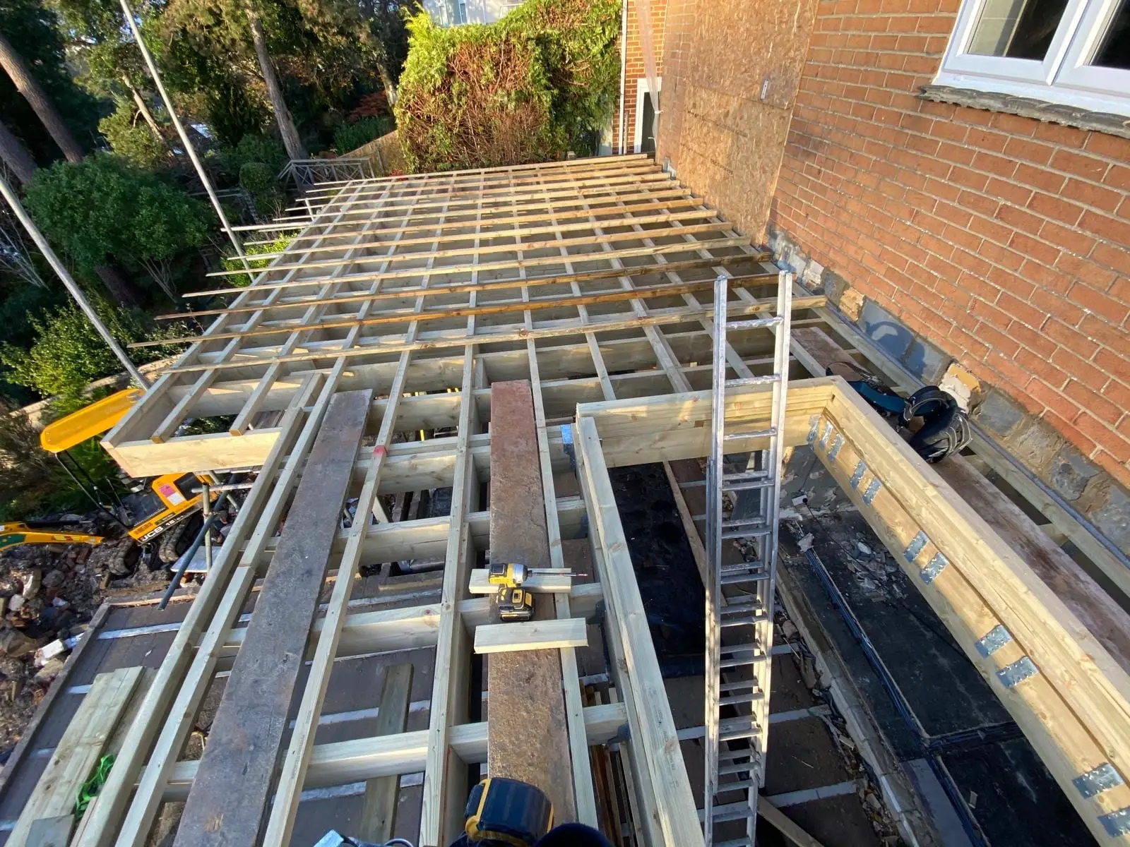 New joists spanning the steel frame, seen from above with the digger still on site