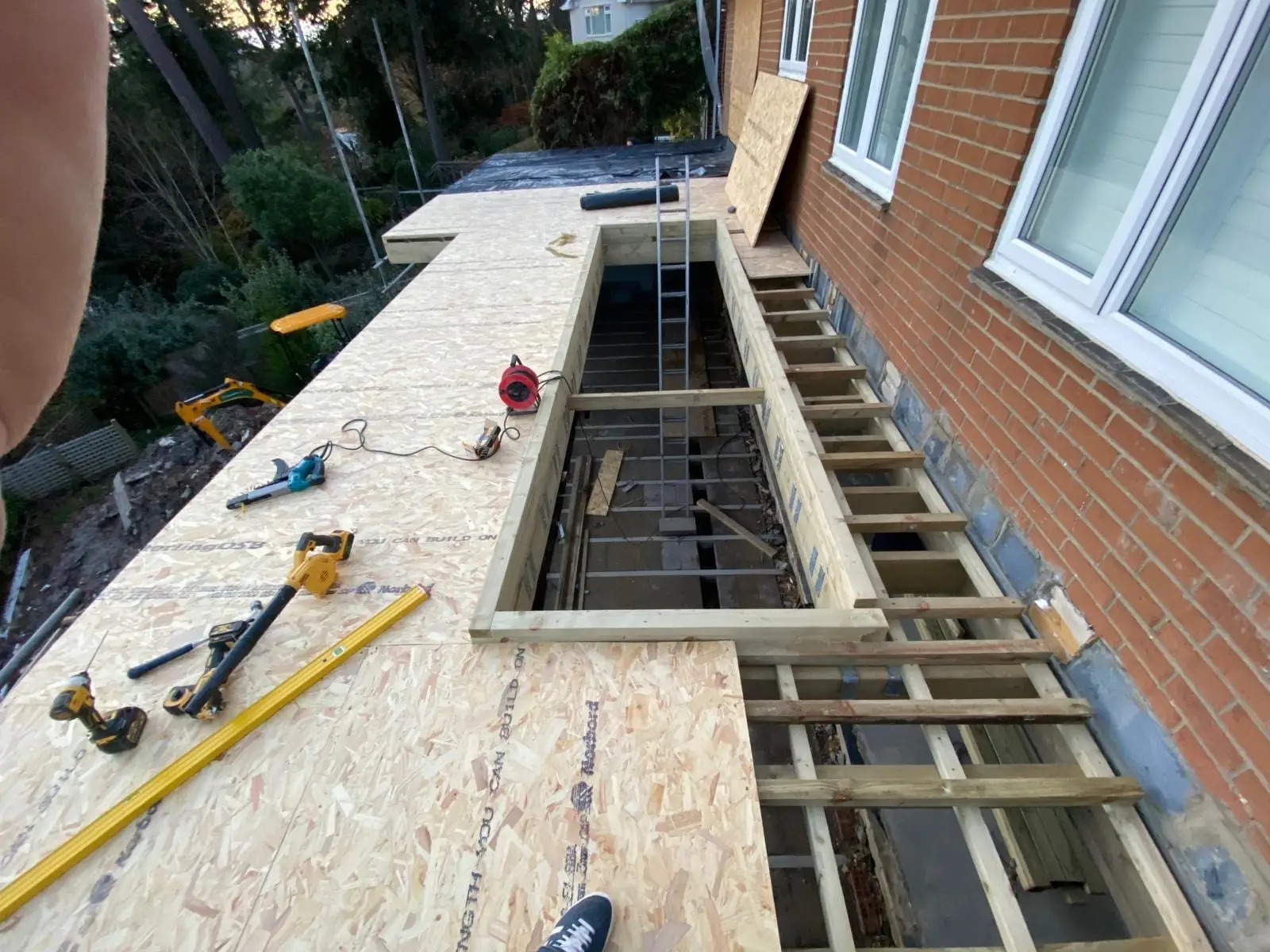 The flat roof decked in OSB with the opening framed out for the glass lantern