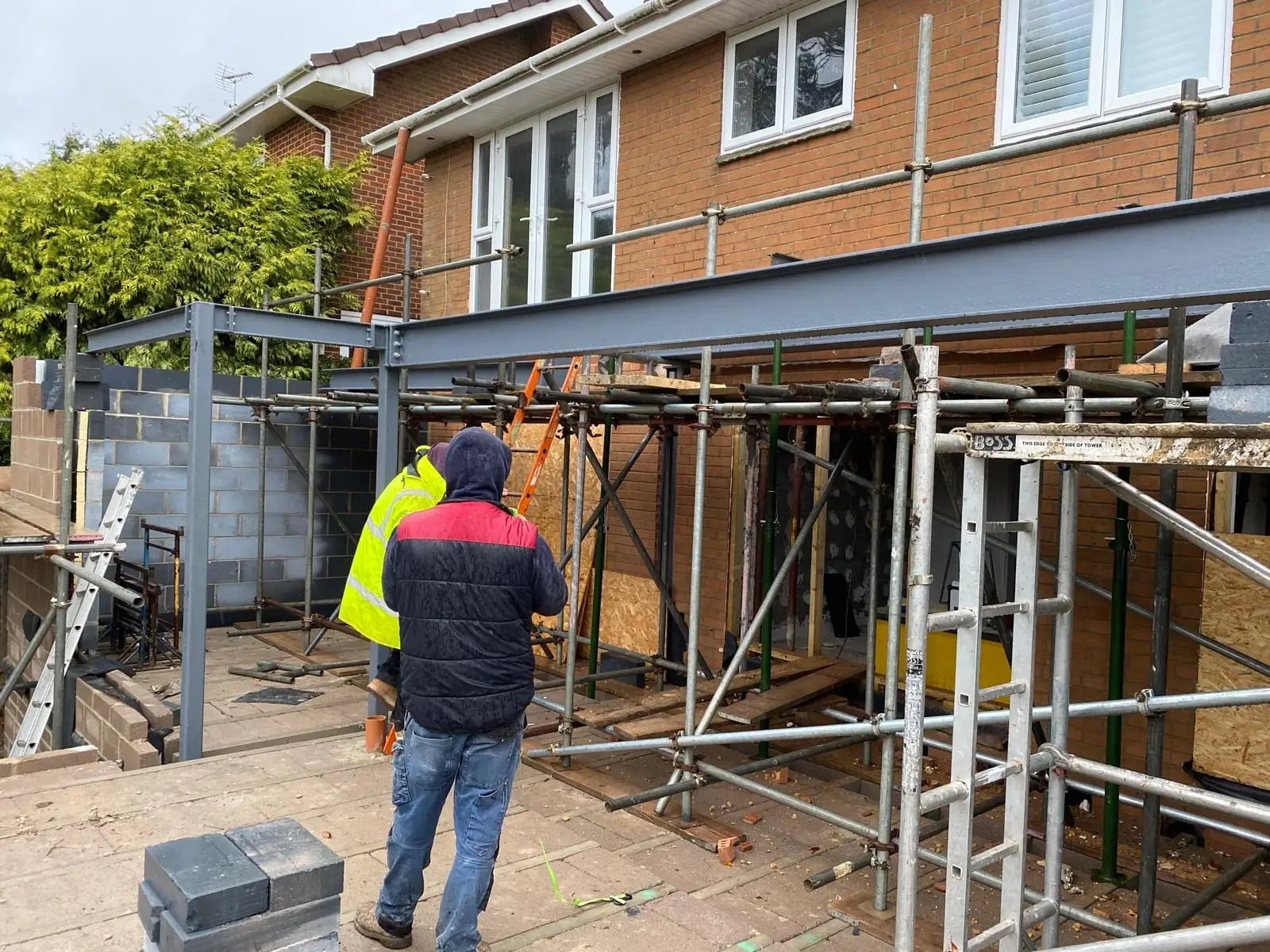 Two of the crew working under the new steelwork at the back of the house